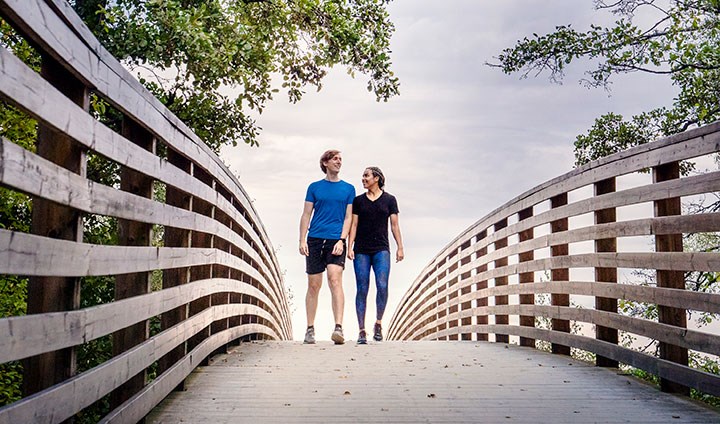 En man och kvinna står på en träbro.