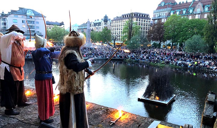 Bågskyttar tänder brasan i Svartån vid Örebro slott.