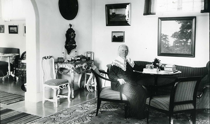 Ellen Key, sittande i en stol vid ett bord i sitt hem Strand.