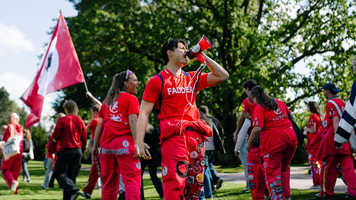 Studenter klädda i corax kläder är glada i stadsparken.