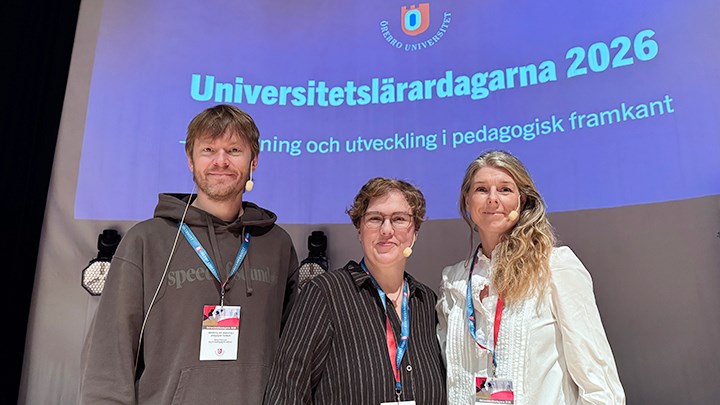 En man och två kvinnor står framför en stor skärm där det står Universitetslärardagarna 2026.