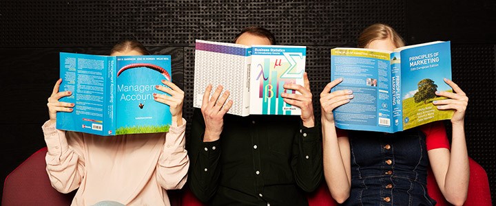 Tre studenter som läser.