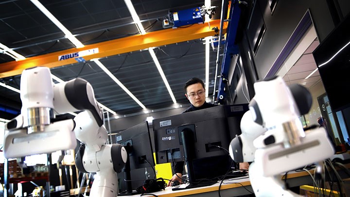 AI-forskare med två robotarmar.