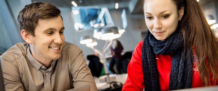 Två studenter sitter framför en dator.