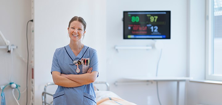 En sjuksköterska vid en sjukhussäng.