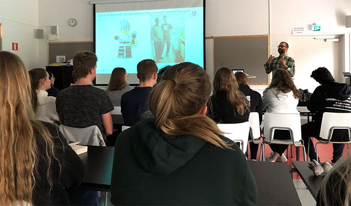 Elever sitter i ett klassrum och lyssnar på en forskare