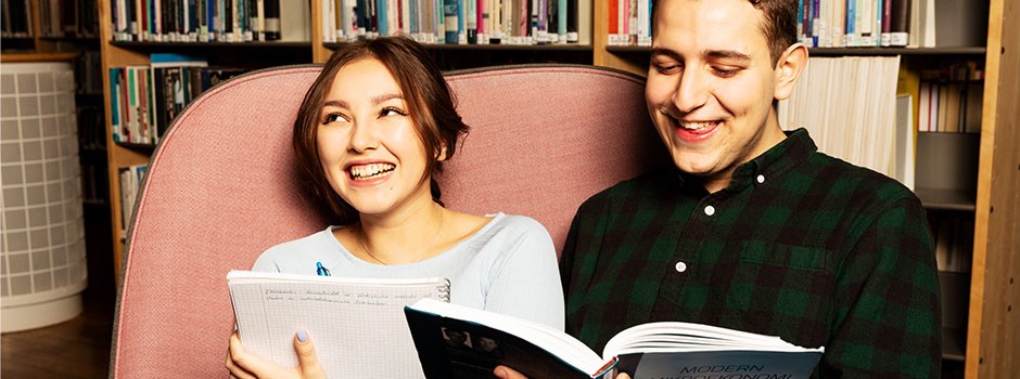 Two students reading a book.