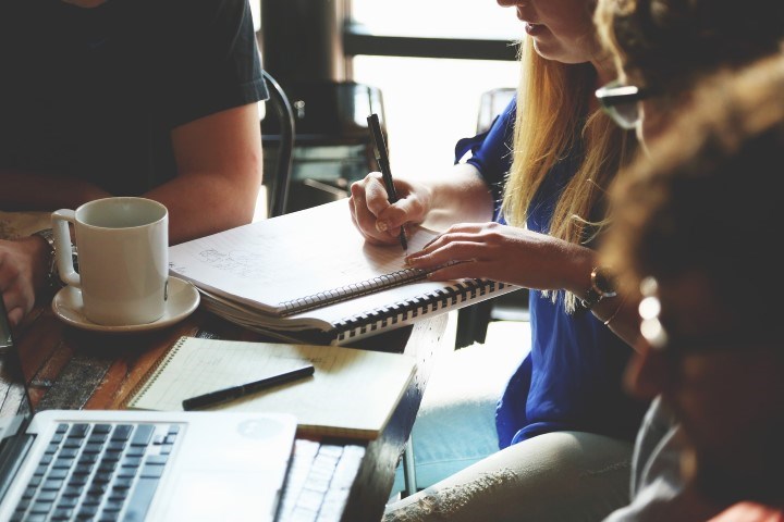 Picture of people making notes at a conference.