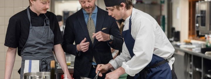 En lärare och två elever i ett restaurangkök