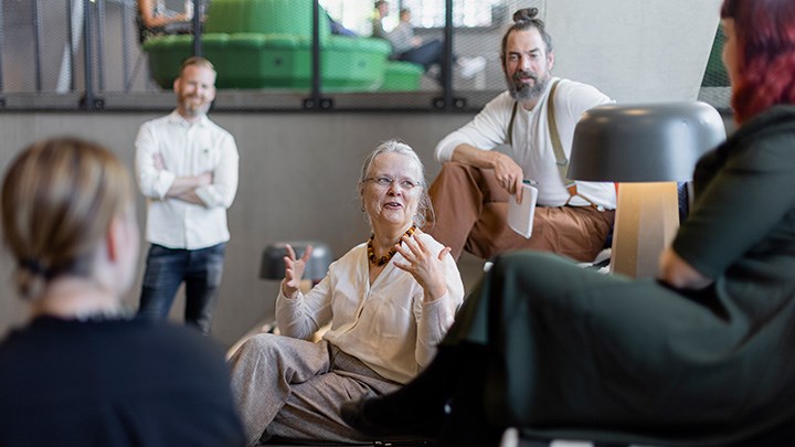 En grupp med människor sitter tillsammans i en trappa och samspråkar. 