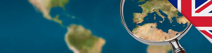 A map of the world, with a magnifying glass of Europe.