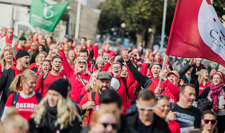Massa studenter med flaggor för sektioner och Örebro studentkår.