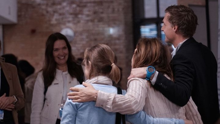 Happy people with arms over their shoulders.