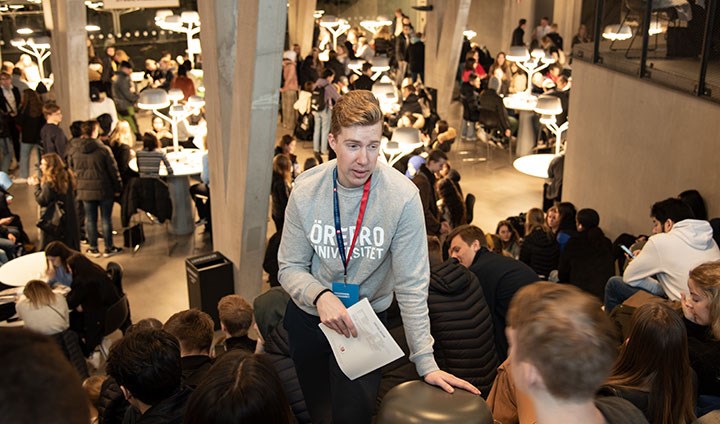 En studentambassadör hjälper gymnasieelever på Universitetsdagarna. Det är trångt i lokalen.