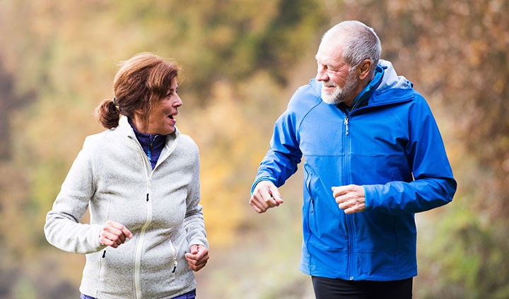 Äldre par är ute och joggar.