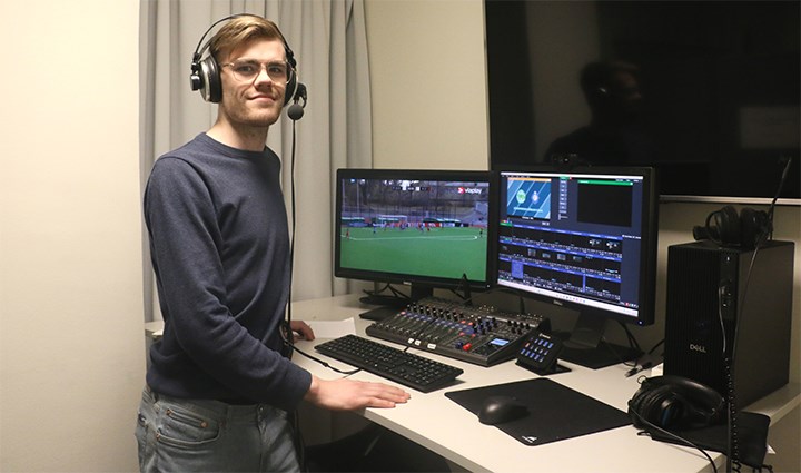 Hampus Gustavsson står vid ett skrivbord på redaktionen i Piteå. Det är två skärmar på skrivbordet.