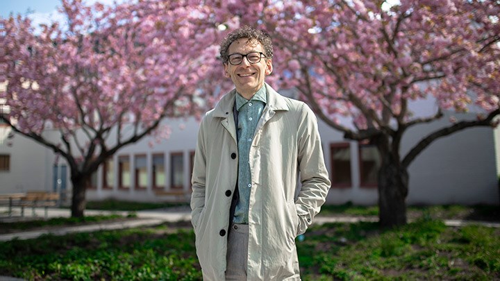 Åke Ingerman framför blommande träd vid Långhuset.