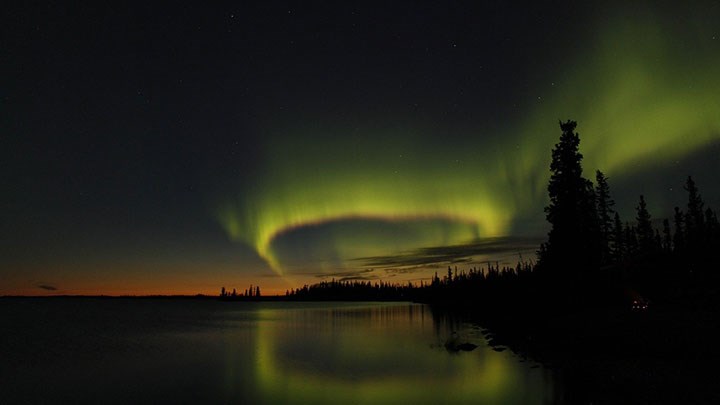Northen light over a forest lake