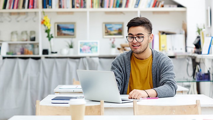 Foto på en student som sitter vid en dator.