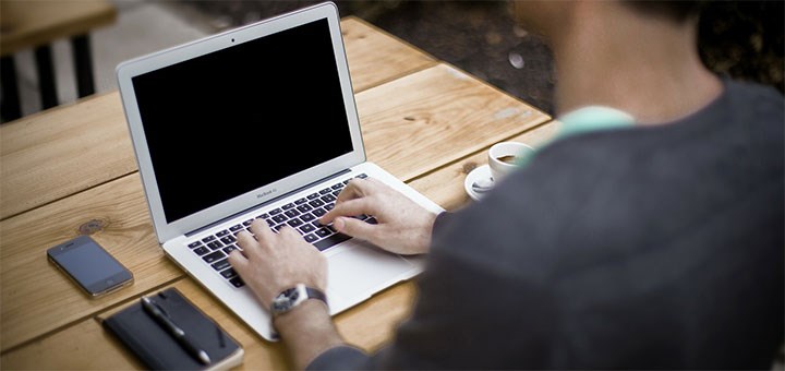 Man skriver på sin laptop.