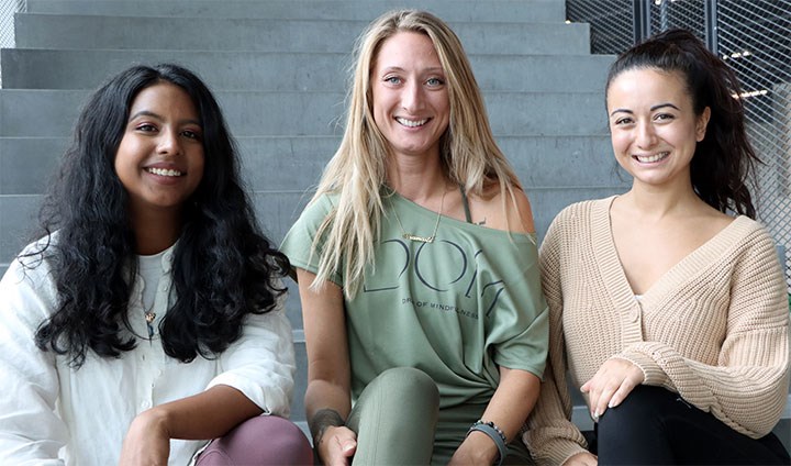 Yasnia Deras Cruz, Frida Wirsén och Caroline Tonojan sitter på en trappa i Nova-huset.