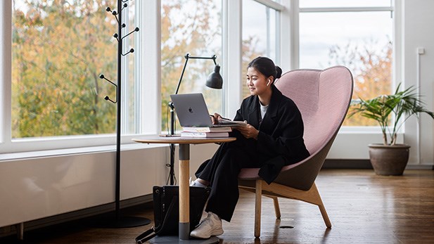 En student sitter med sin dator och studerar.
