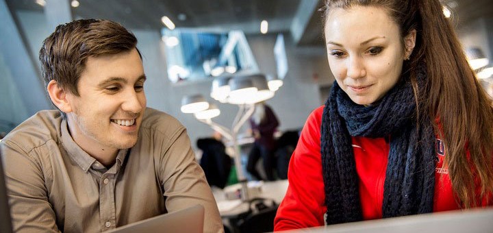 Två studenter tittar på en skärm.