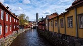 Foto på en kanal som flyter mellan äldre svenska byggnader.