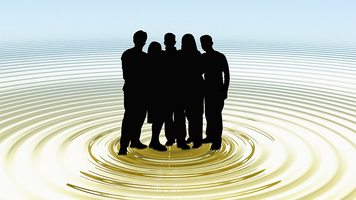 Silhuett av fem personer som st&aring;r tillsammans.  