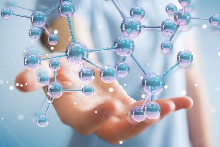 Hand holding molecule structure.