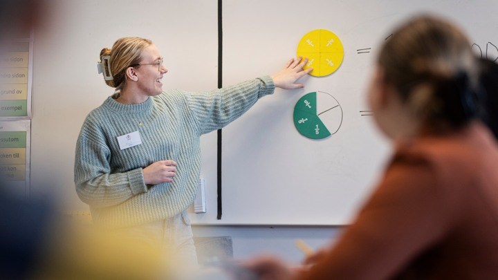 Teacher showing geometric shapes on white board