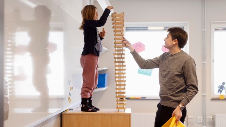 Child building a tower with wooden blocks in class a class room