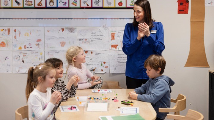 Children sitting around a table in a class room