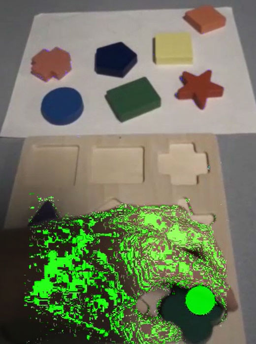 Puzzle with different shapes and a green dot showing the eye gaze of the person. 