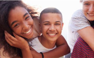 Three young people looking into the camera. They look happy.