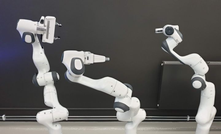 Bild på tre stycken robotarmar.