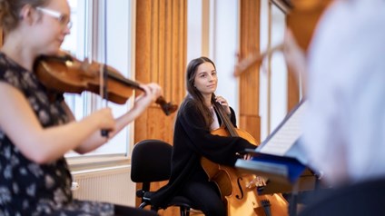 Two female violinists are playing together.