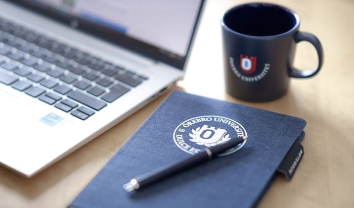 Computer, notebook, pen and mug