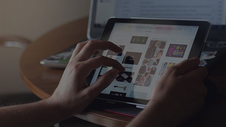 Two hands holding a tablet.