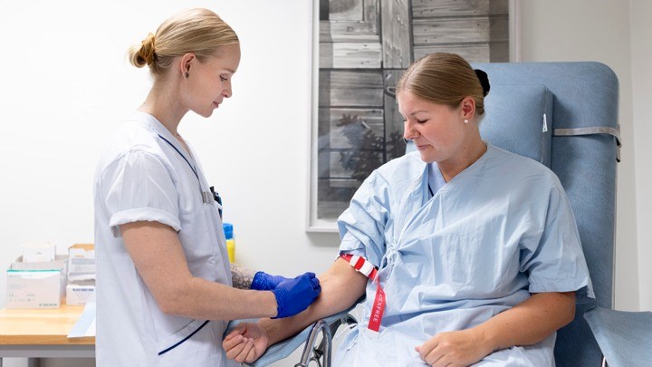 En sjuksköterska tar ett blodprov på en patient. 