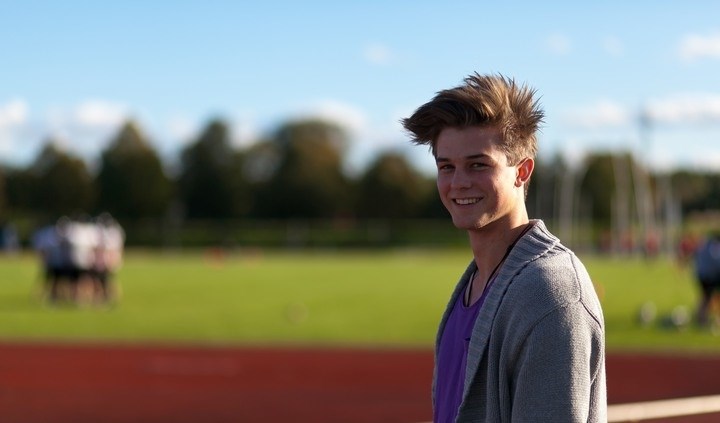 Photo of student standing by running tracks.