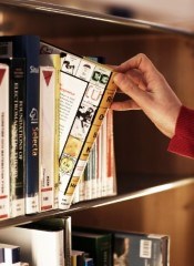 Close-up of a hand taking a book from a shelf