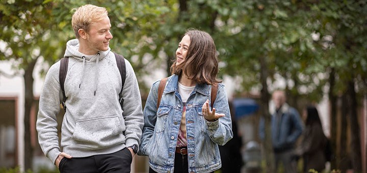 Två studenter pratar på campus.