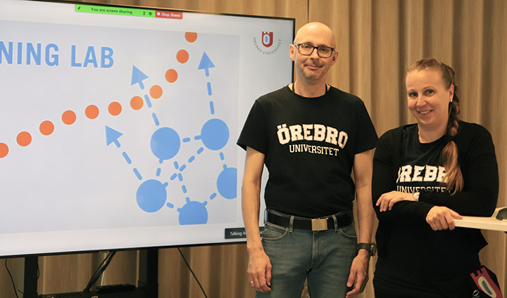 Magnus Hansson och Anna-Eva Olsson står bredvid en skärm som visar Learning Labs logga.