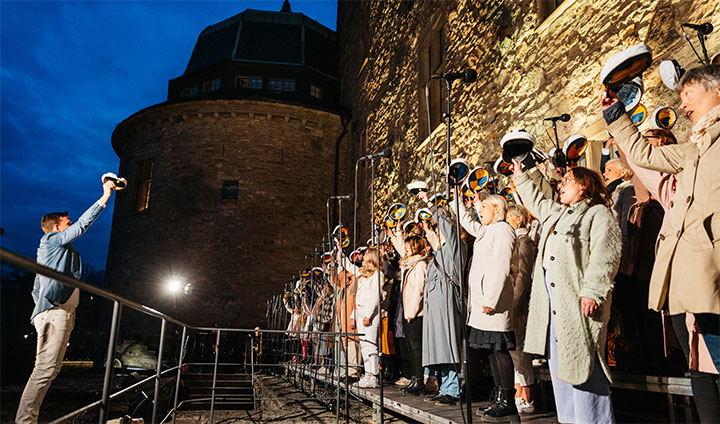 Kören viftar med sina studentmössor.