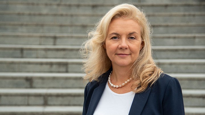 Susanne Strand in front of a grey staricase.