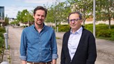 Två personer står utomhus.