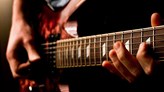 Närbild på elgitarr med händer