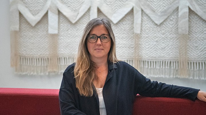 Jenny Alsarve sitter på en soffa.