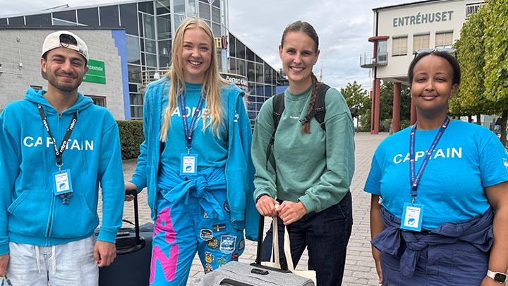 Fyra studenter står utomhus framför Kårhuset.